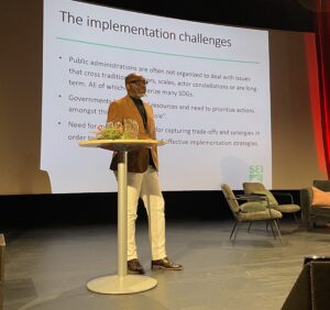 Nelson Ekane giving a speech on a stage